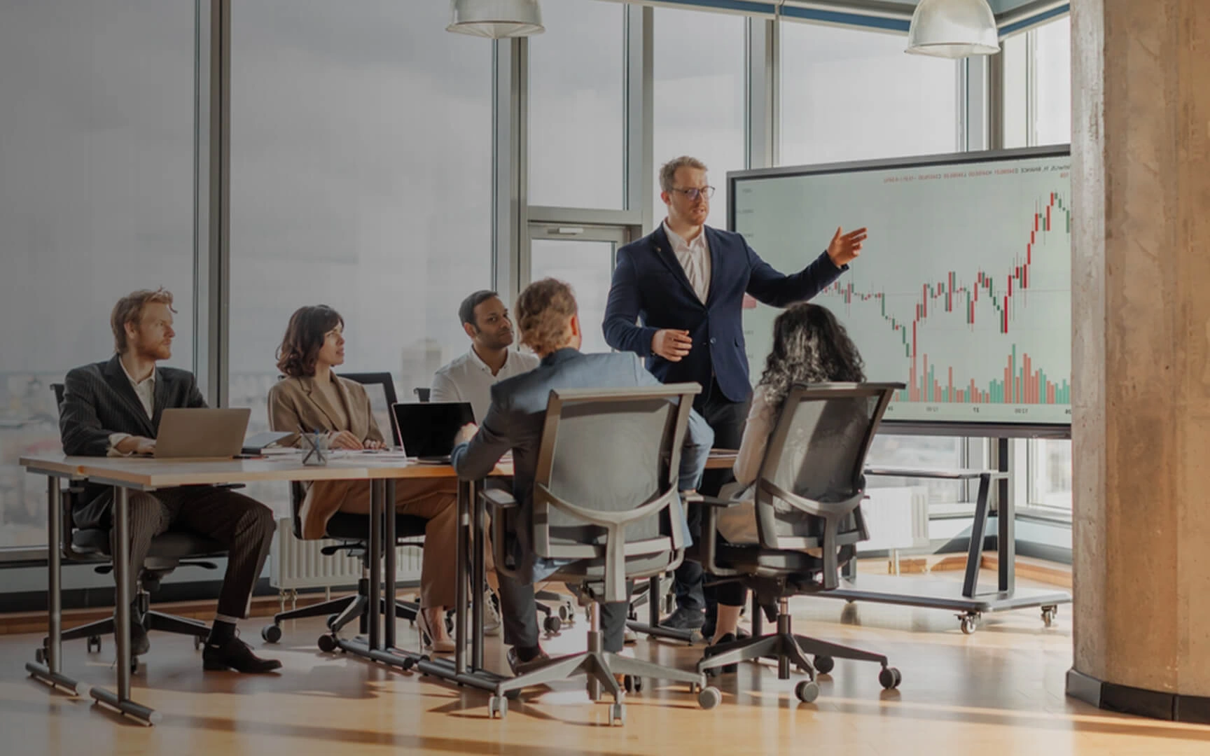 Professionals in een vergaderruimte terwijl een presentator financiële prestatiegegevens bespreekt op een groot scherm, wat staat voor strategische planning, AI-gestuurde finance inzichten en besluitvorming.