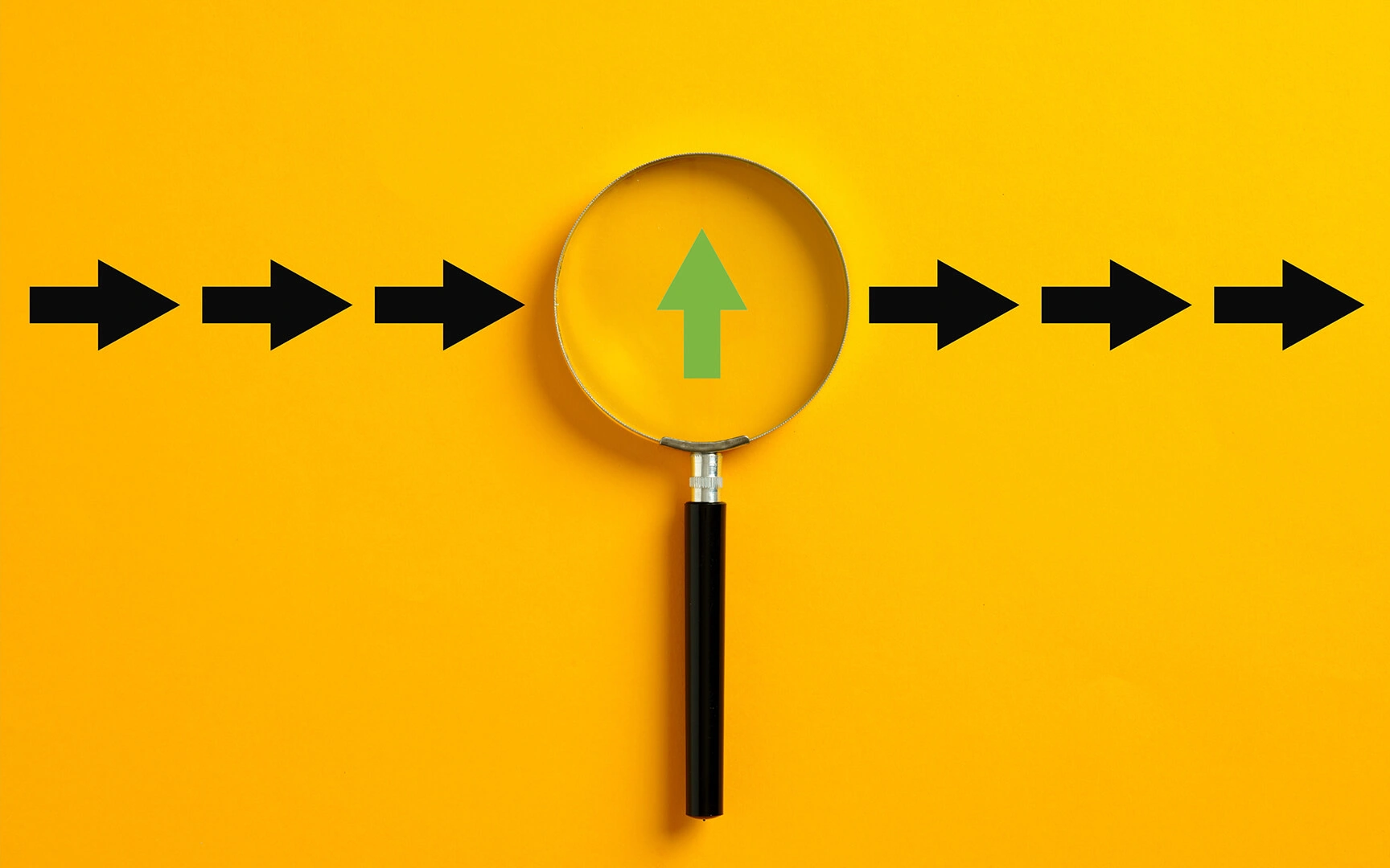 A magnifying glass with a black handle centered over a yellow background, showing a green upward arrow with black arrows pointing right.