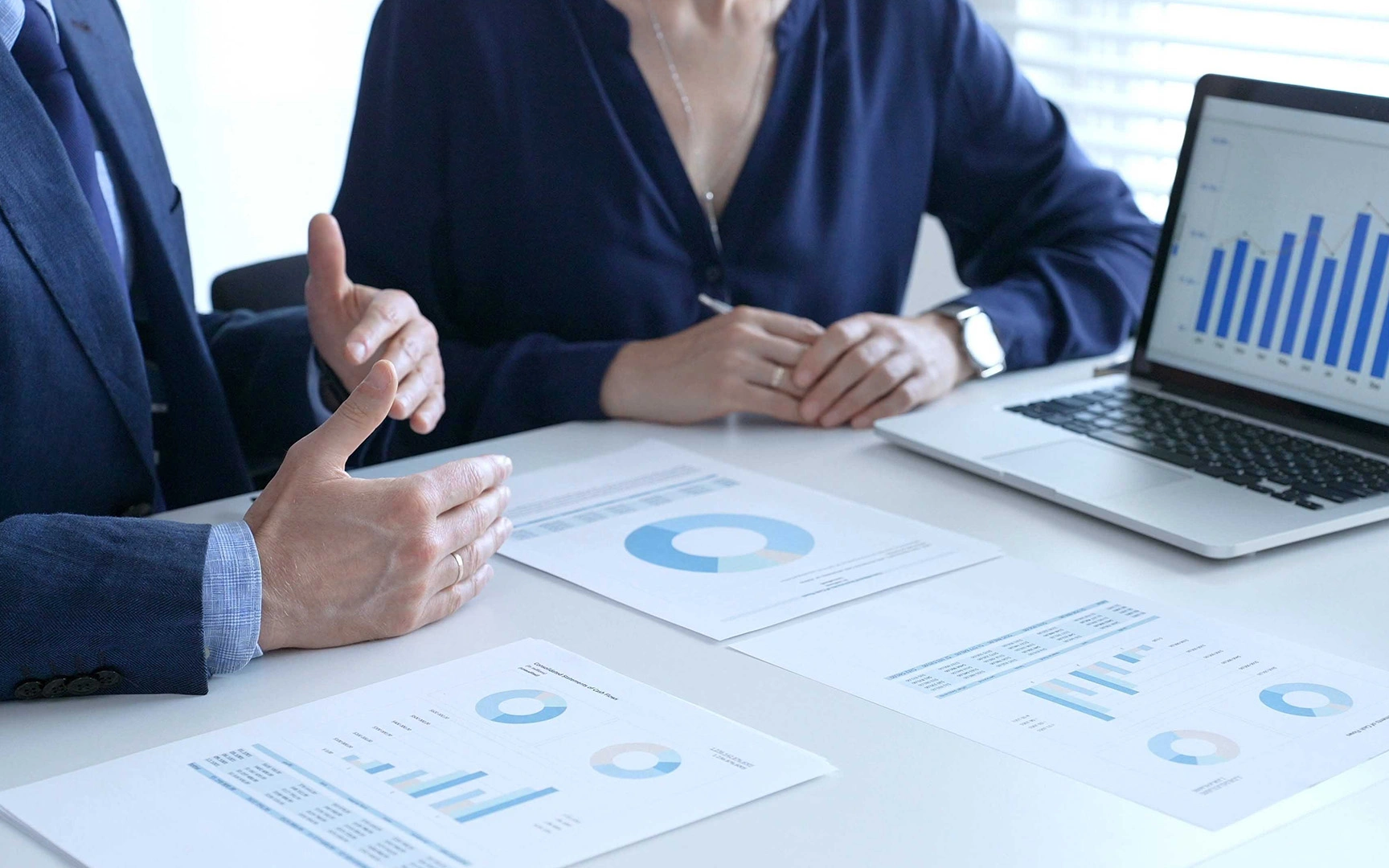 Business professionals reviewing financial reports and performance metrics during a meeting.