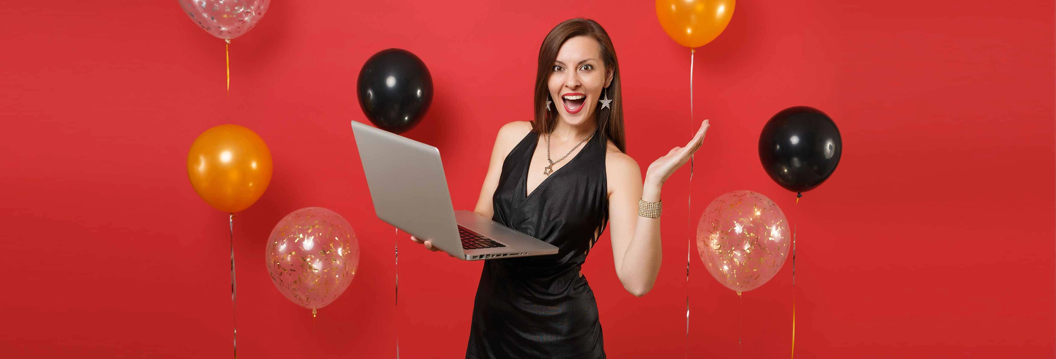 person celebrating with laptop and balloons