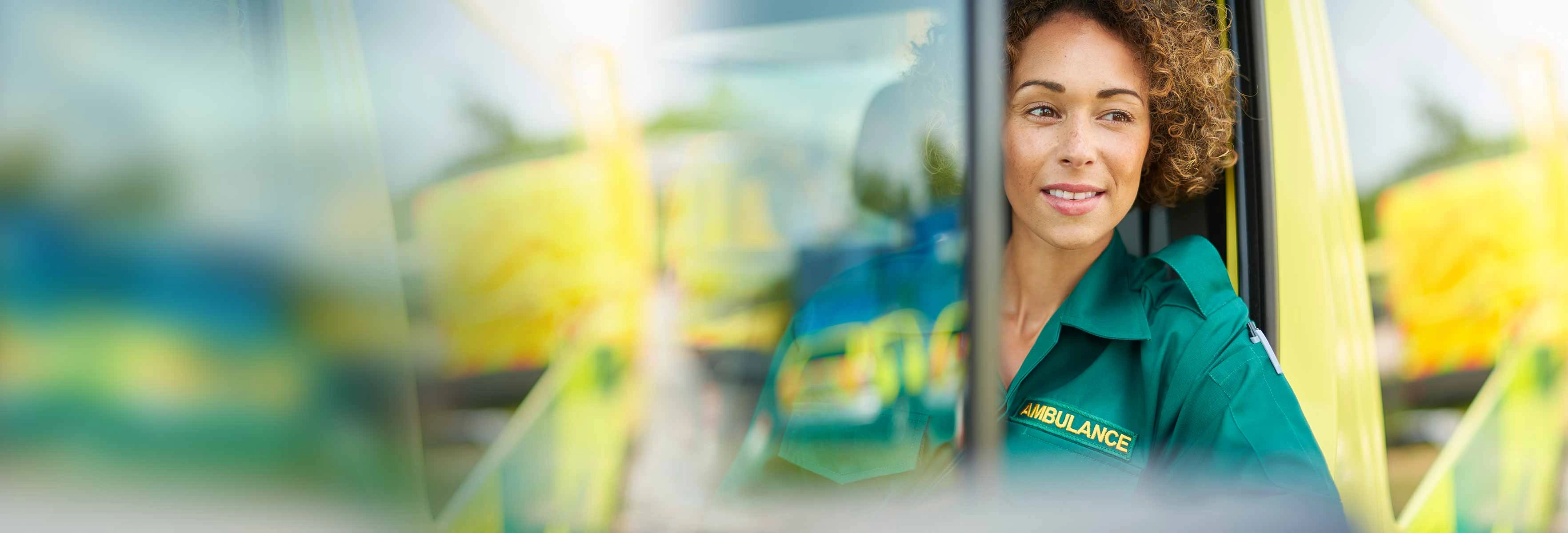 a woman in a paramedic uniform sat in the front of an ambulance