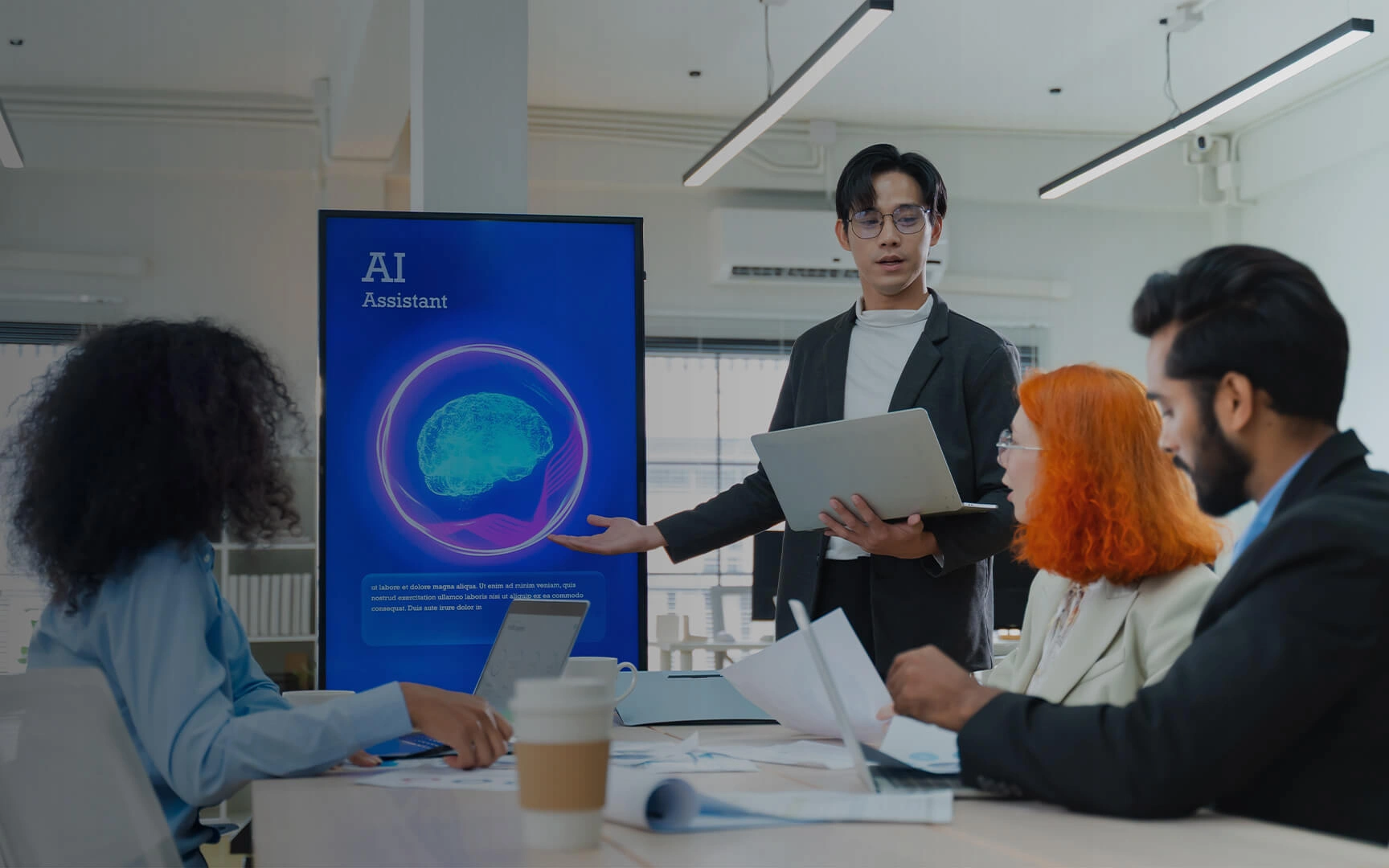 Équipe dans un bureau moderne examinant une présentation sur l'assistant IA, avec un intervenant expliquant l'analyse des données sur un grand écran lors d'une réunion de travail collaborative.