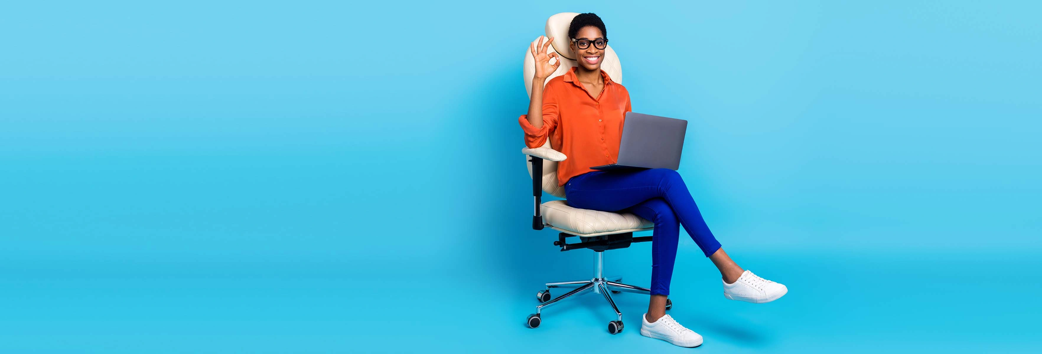 woman sitting on office chair with laptop on lap