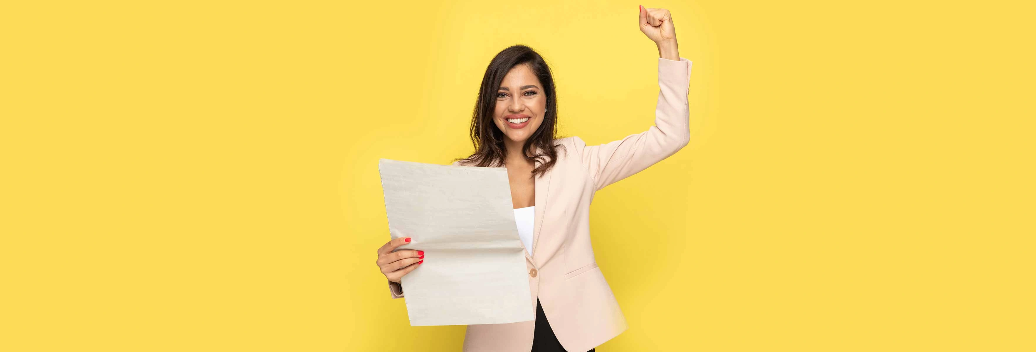 person with paper on yellow background