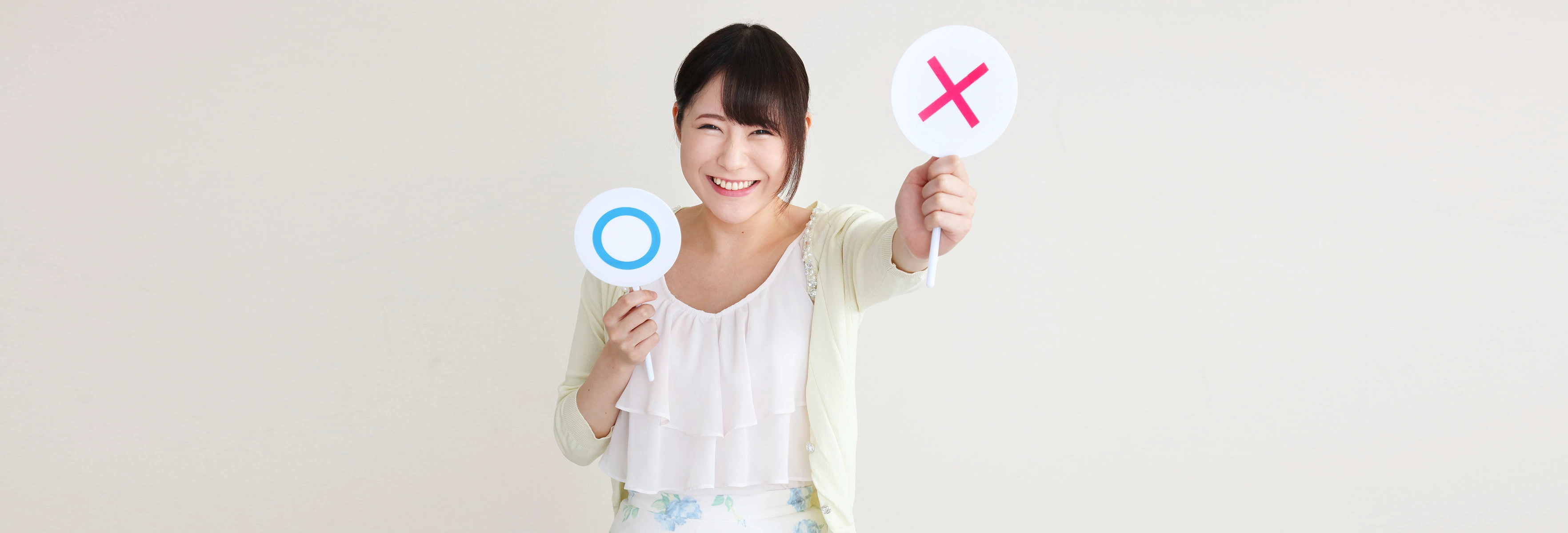 woman holding two signs with letters x and o