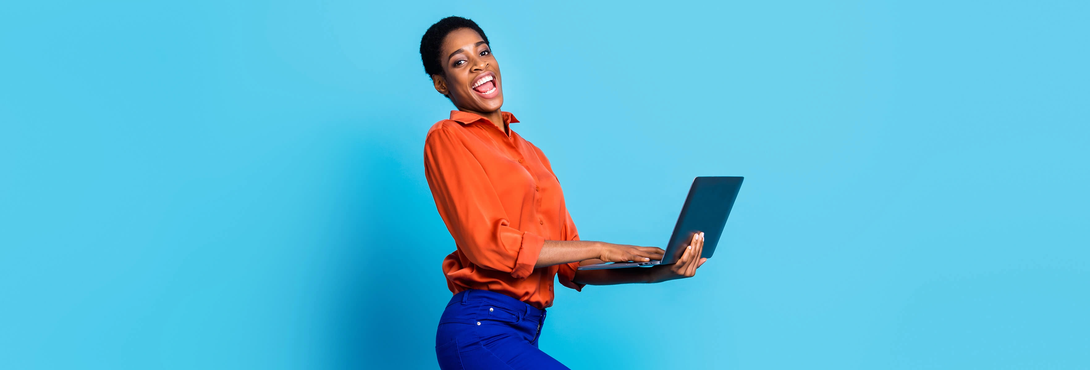woman smiling holding laptop