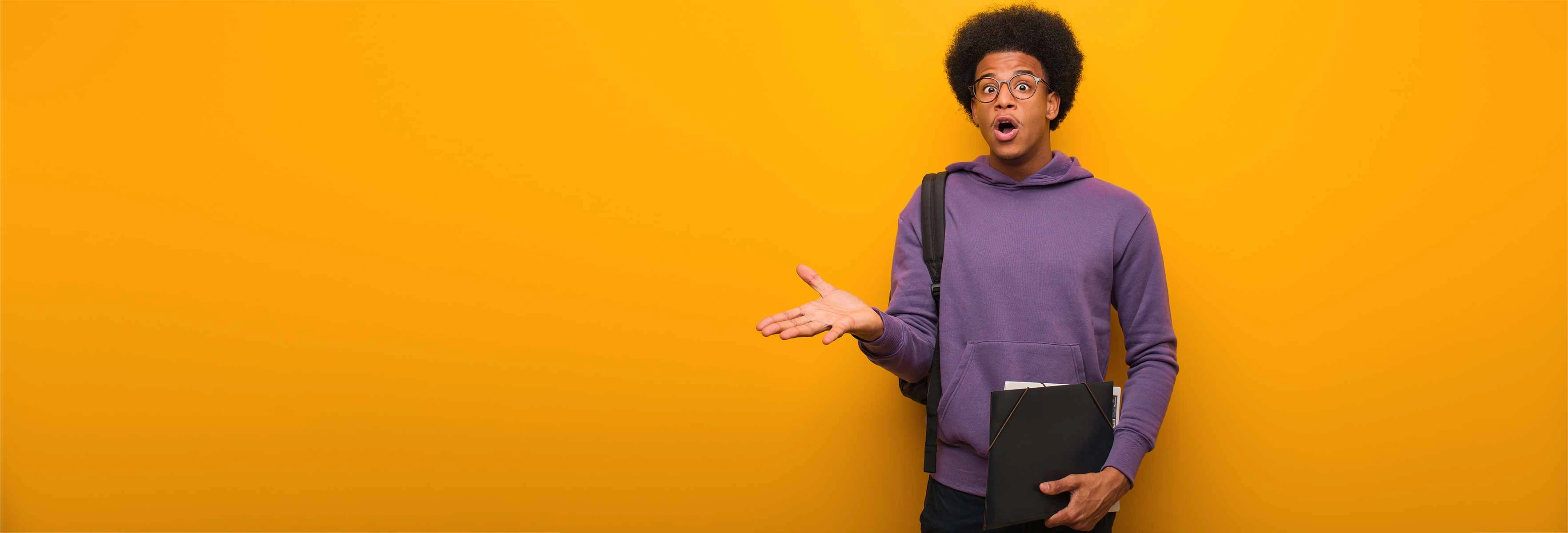 young man in front of orange background looking shocked