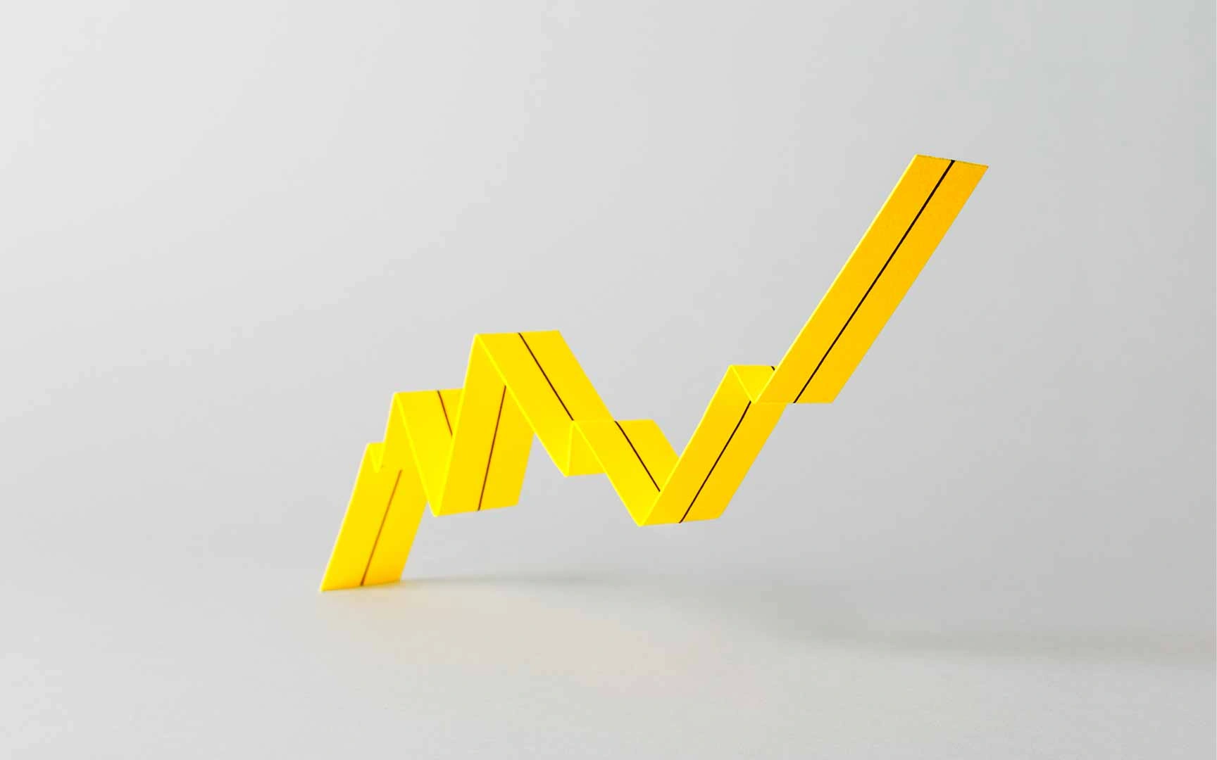 a 3 dimensional bar chart in yellow showing a steady increase on a grey background