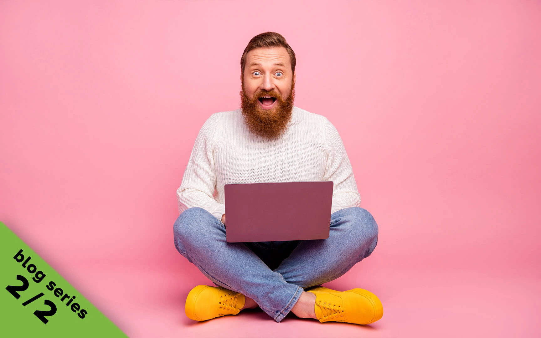 man smiling behind laptop