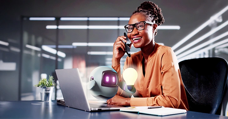 A professional is sitting at a desk with a laptop, conversing on the phone and interacting with an AI assistant in a modern office setting.