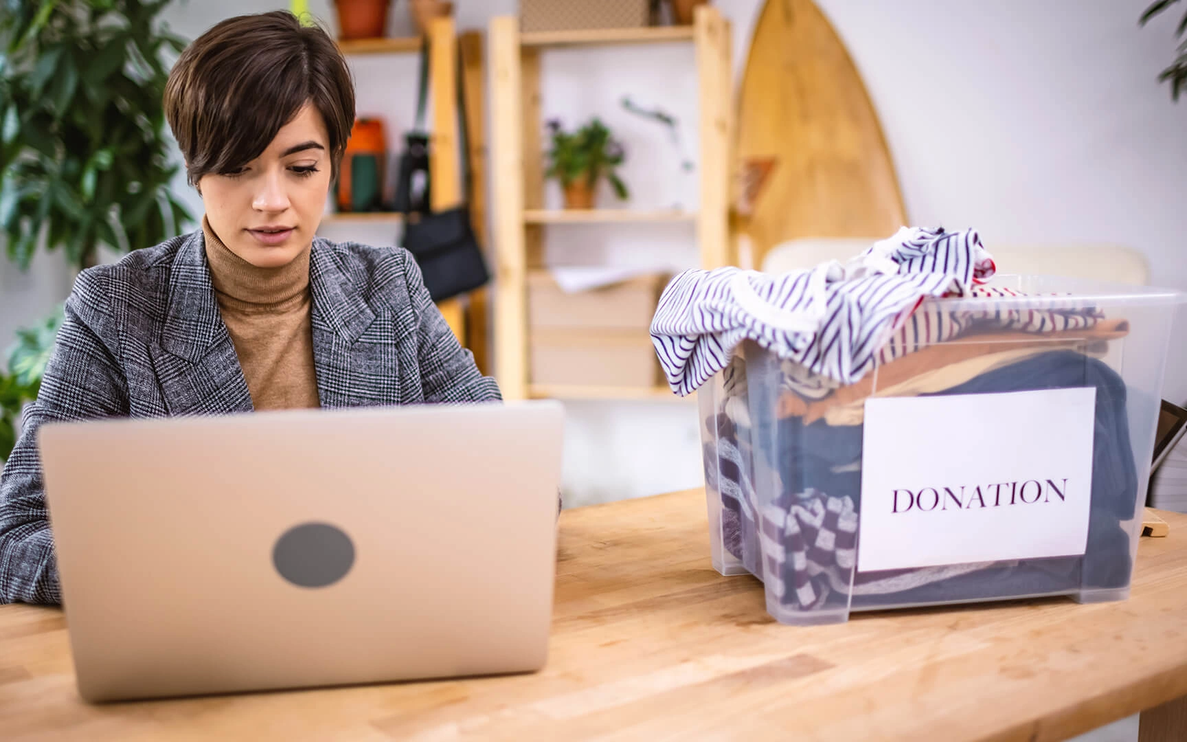 Woman on her desk, looking at laptop
