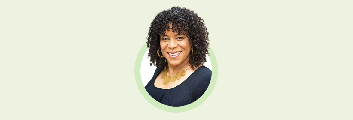 Portrait of Jennifer Sherman, Unit4's Chief Product Officer, smiling with curly hair, wearing a black top and a gold necklace, set against a light green circle and a beige background.