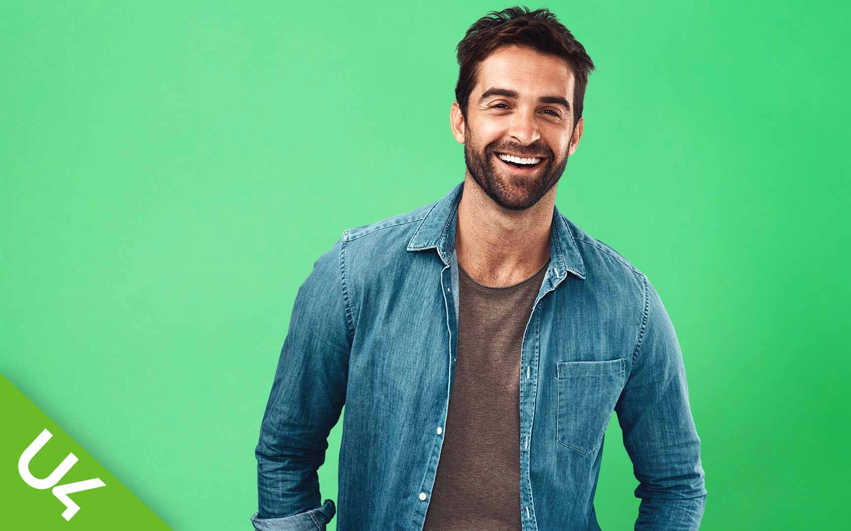 smiling man looking straight ahead on a mid green background