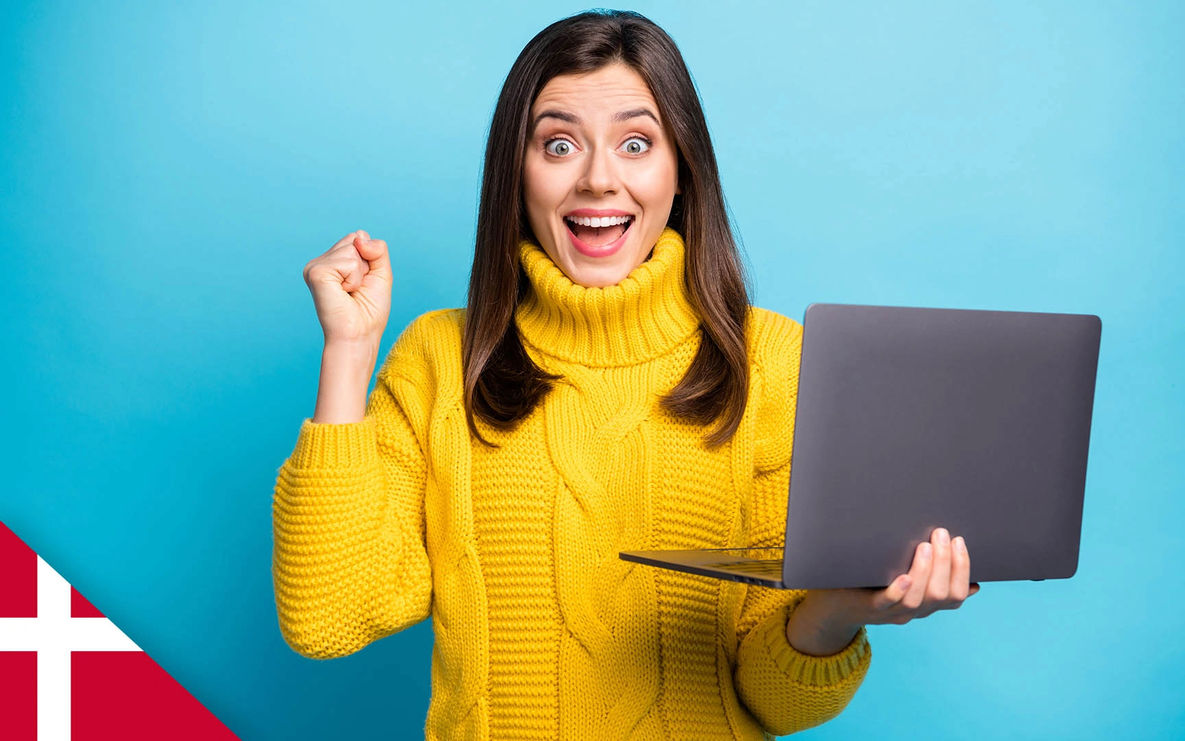 Woman holding laptop in one hand, other hand clenched in celebration