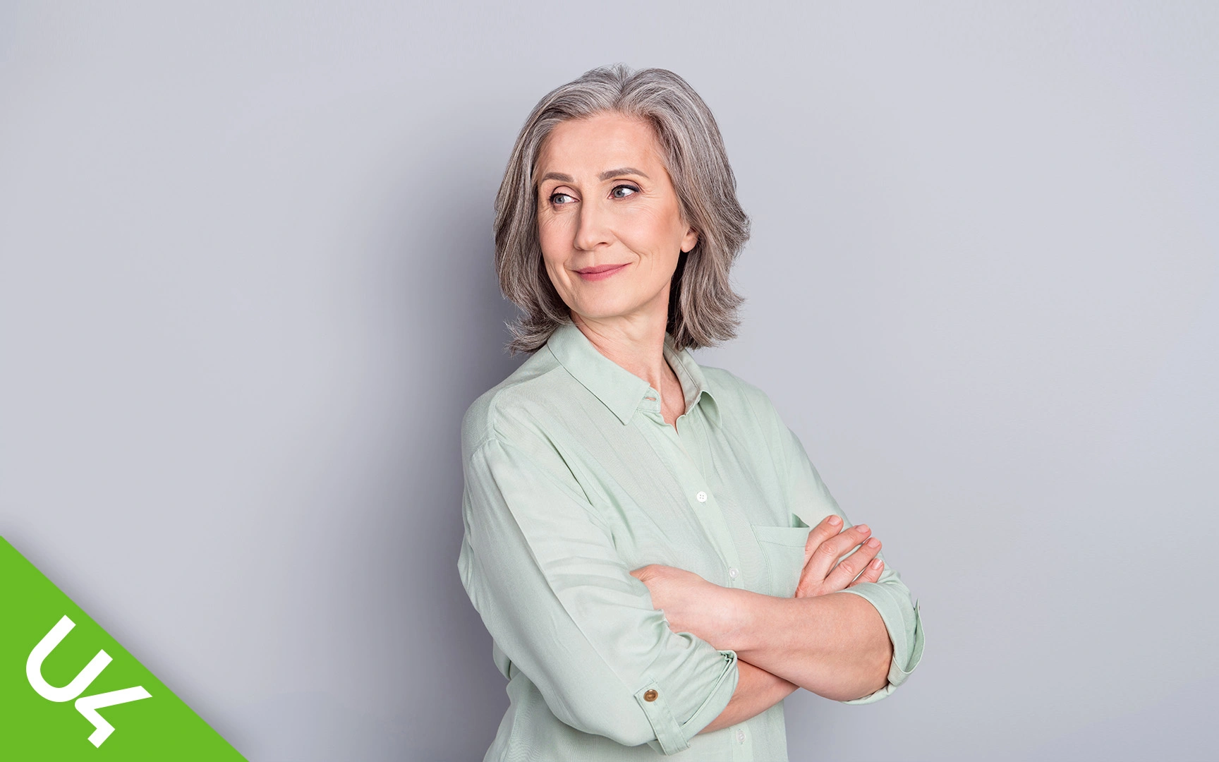 smiling woman, arms folded, looking sideways