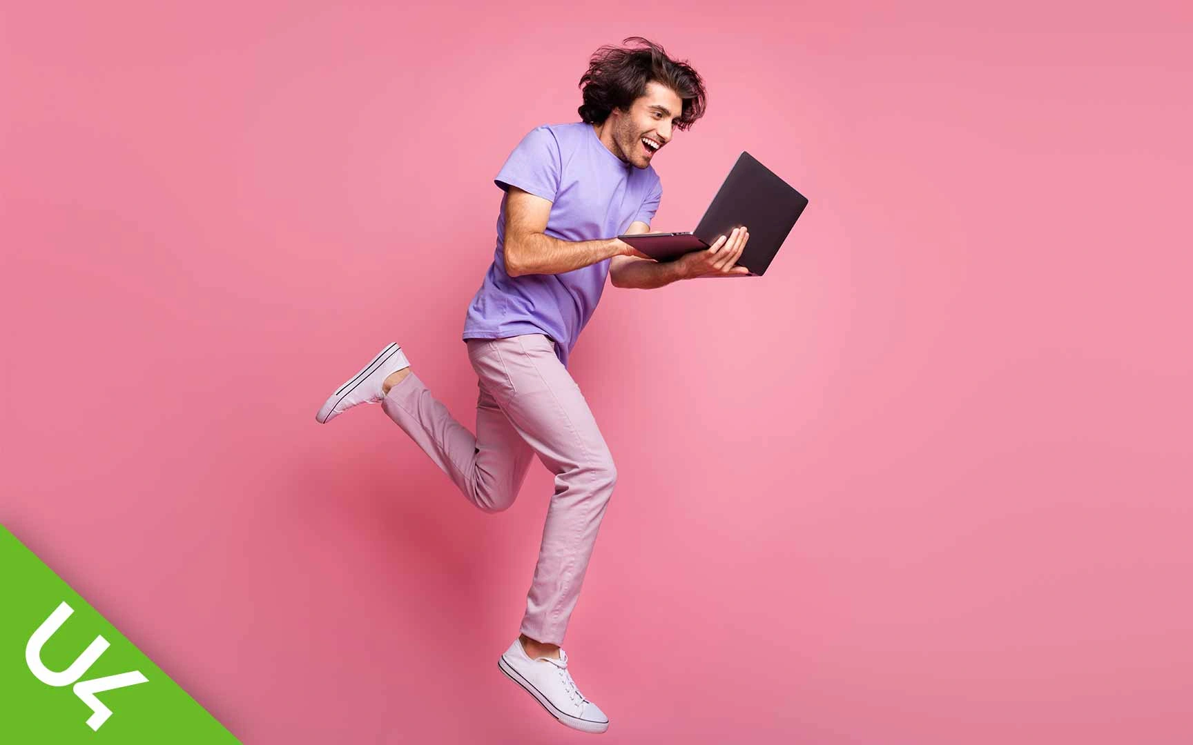 Man holding and typing on laptop as he runs
