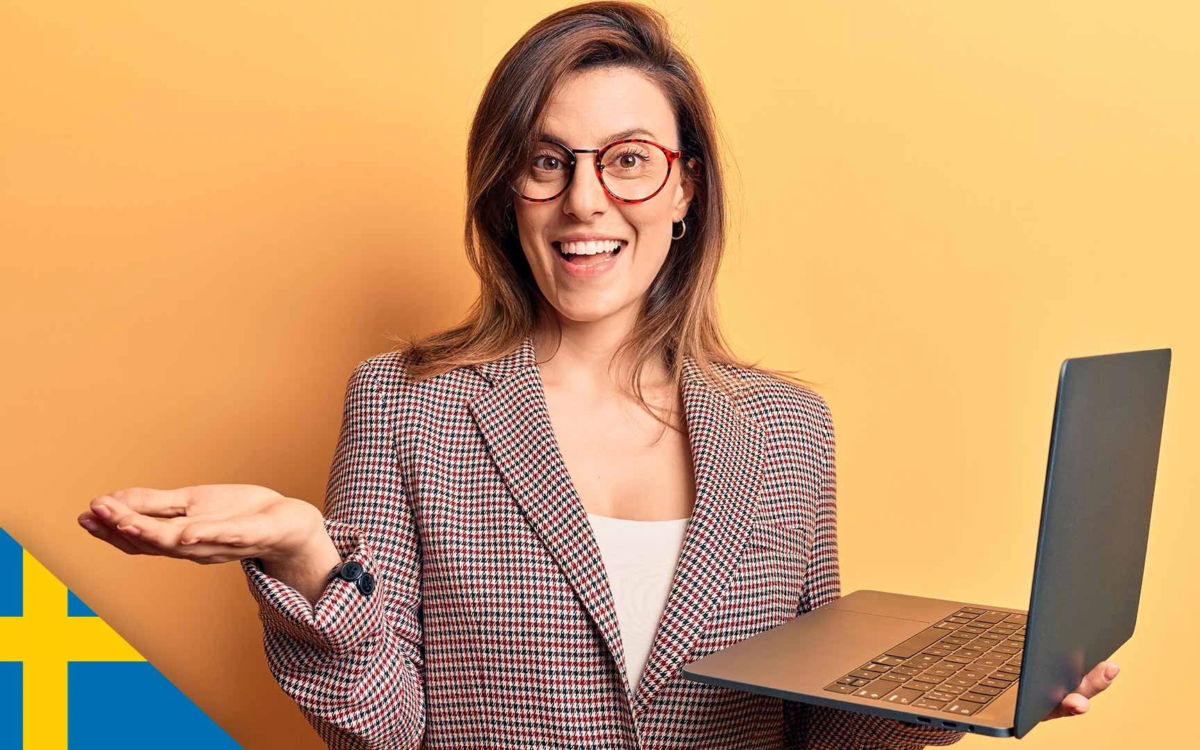woman, smiling and holding laptop, gesturing with free hand