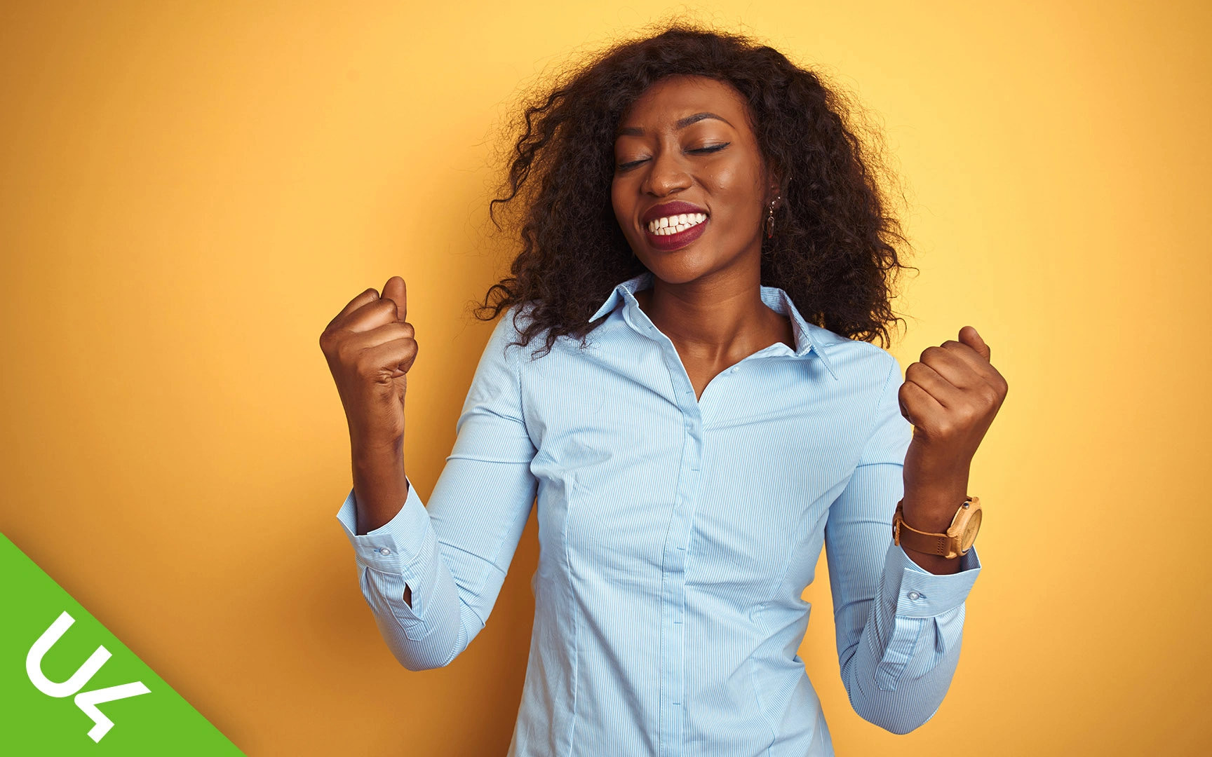 Woman smiling, with both hands half raised in celebration