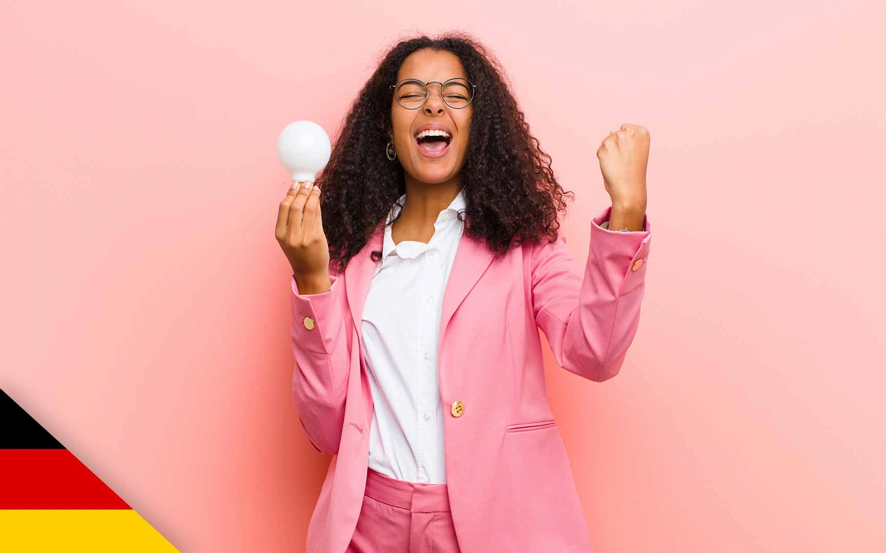 Woman shouting in celebration; holding lightbulb in one hand otehr hand clenched and half raised