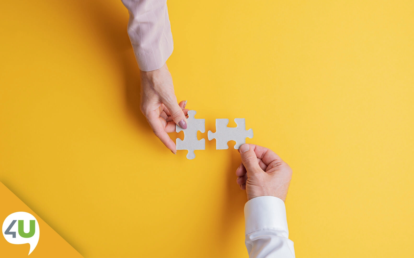 Two hands joining putting together puzzle pieces