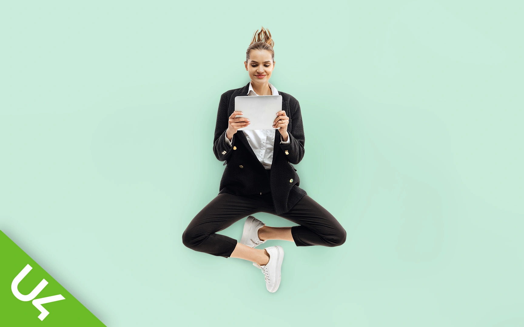 Woman floating in mid air holding tablet computer