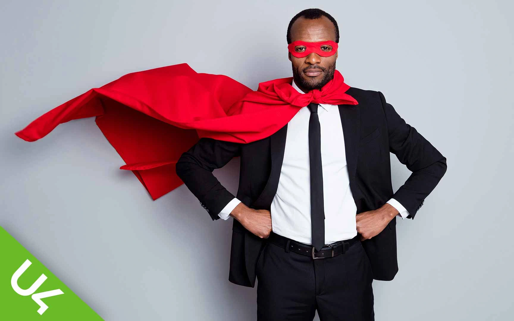 Man in suit wearing superhero cloak and mask