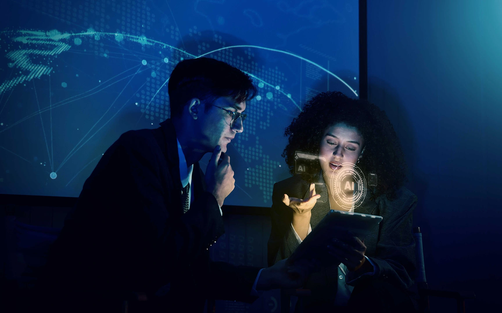 Two professionals review information on a tablet in a dimly lit office, with AI interface graphics and a global digital network displayed in the background, illustrating explainable AI and data-driven decision-making in finance.