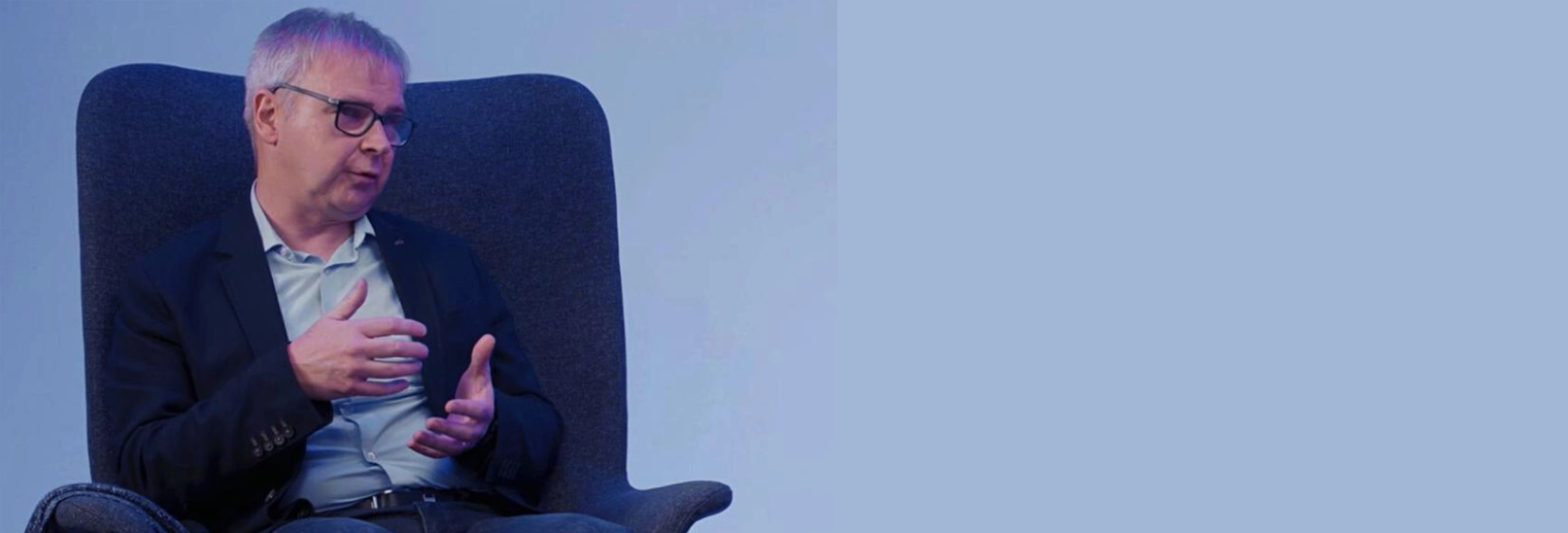 Man with glasses sitting in a chair
